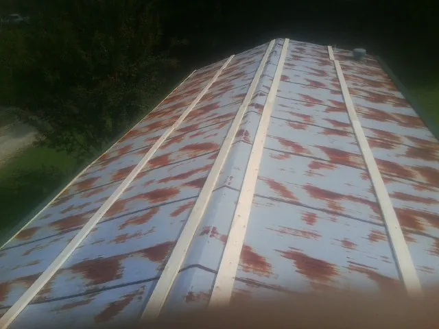 Rusted metal roof panels with new wood purlins before replacement — Storm Damage Roof Repair in Mc Dade by Roofing Brothers