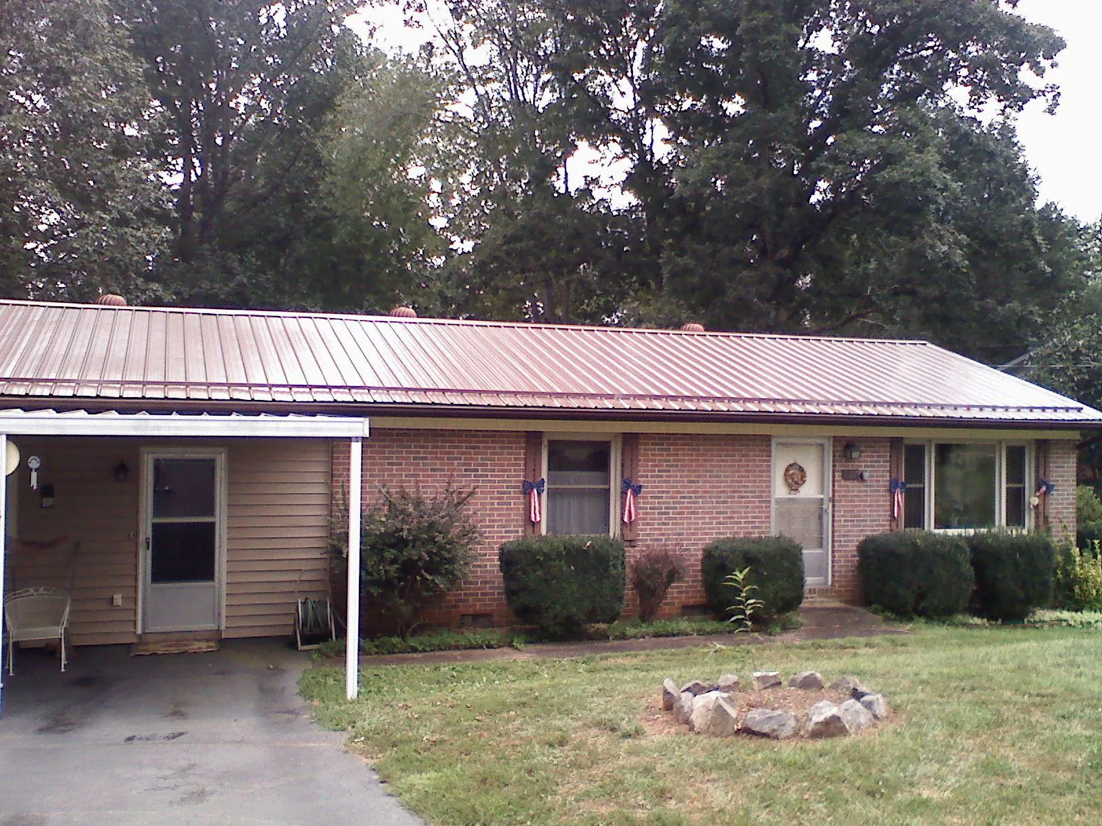 Bronze metal roof and carport on a brick ranch home — Roof Repair work by our crew in Mc Dade