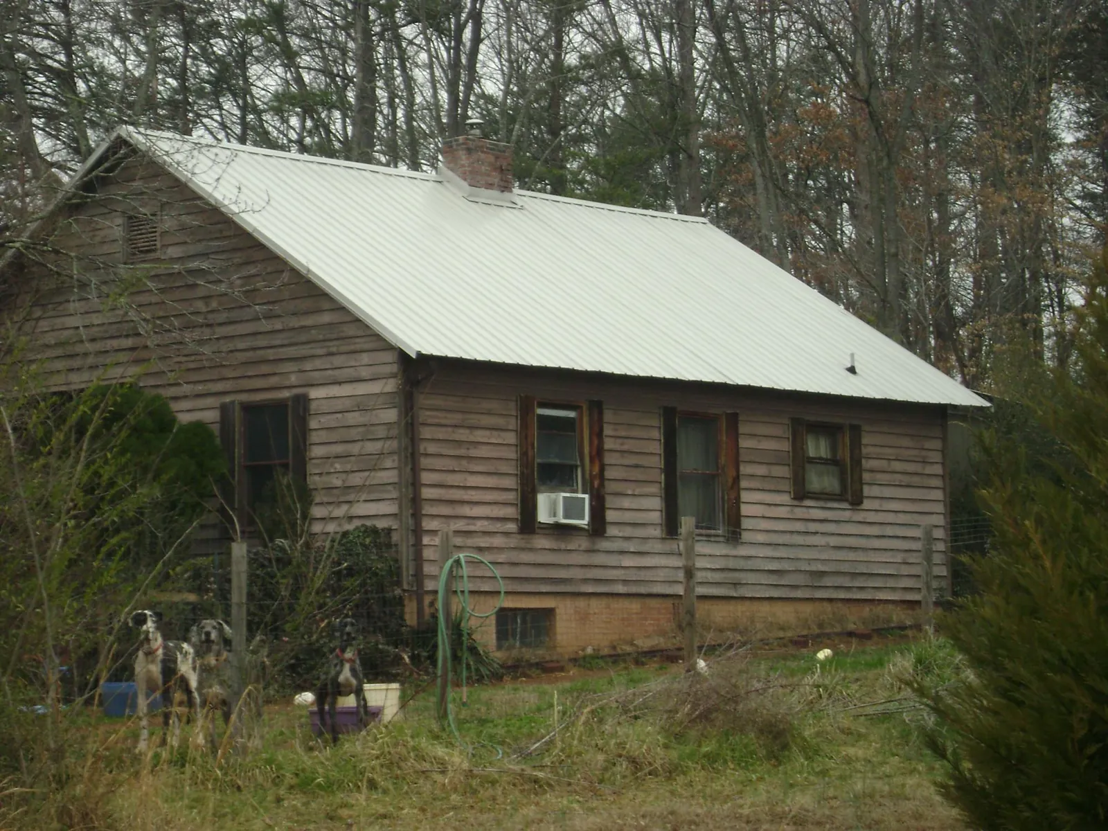White metal roof on an old wood sided farmhouse, from a Metal Roof Installation job in Mc Dade